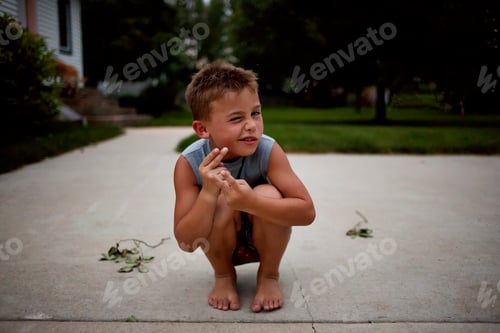 Preview: Boy Makes Silly Face While Squatting Outside