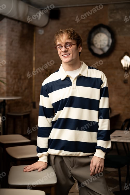 Preview: Young man enjoying his time in a modern cafe with a cheerful smile