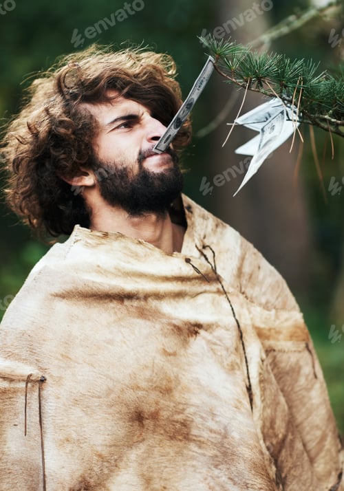 Preview: Back then money did grow on trees. A confused caveman biting money off of a tree.