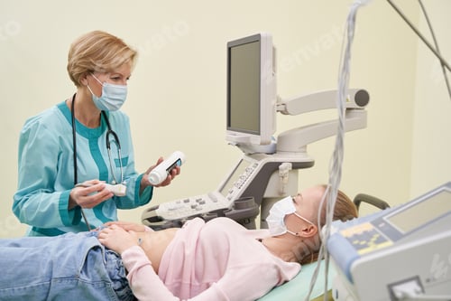 Preview: Pleased medical worker putting gel on the stomach