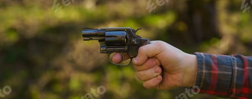 Preview: Unrecognizable man with revolver aiming target on shooting range training outdoors.