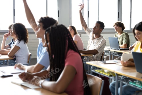 Preview: Teen raising hand to ask question about lesson in classroom.Group of multiracial highschool students