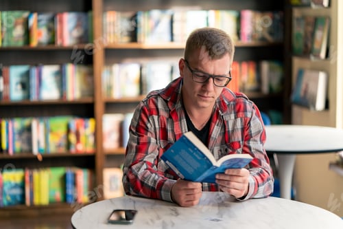 Preview: professor sits in a scientific and technical library reads a book and prepares write a dissertation