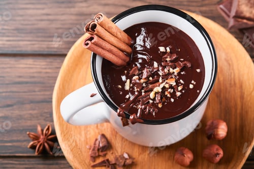 Preview: Hot chocolate. Homemade spicy hot chocolate with cinnamon, crushed hazelnut in enamel mug on old woo