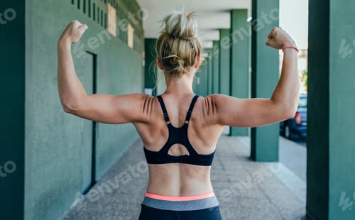 Preview: Sportswoman on her back showing muscles