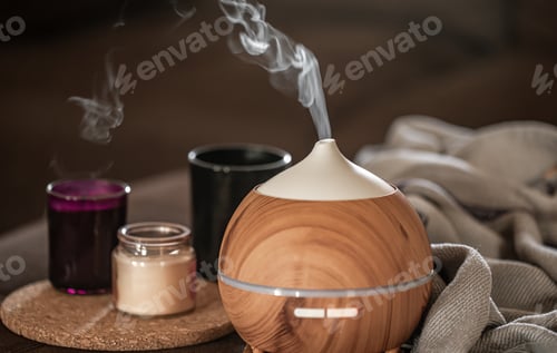 Preview: Oil diffuser on blurred background near candles close up.