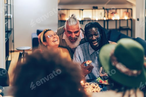 Preview: multi ethnic friends laughing sitting a table at dinner