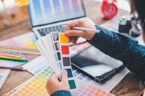 Preview: Graphic designer architects who work with laptops and color comparison tables for design work.