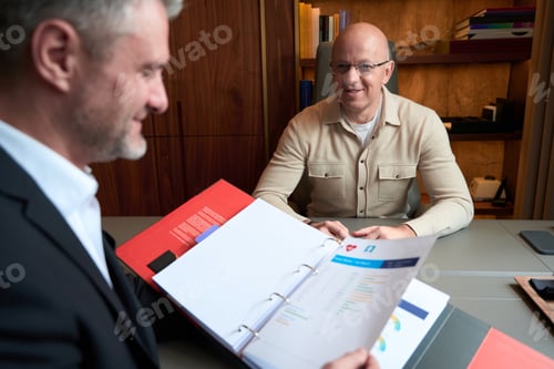 Preview: Handsome male having negotiation with business partner in the modern cabinet