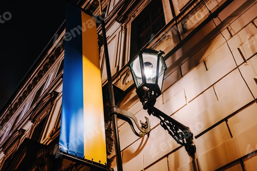 Preview: Ukrainian flag on european building near night lantern.