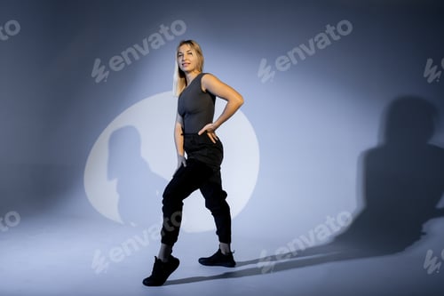 Preview: Confident dancer posing in studio with projected shadows