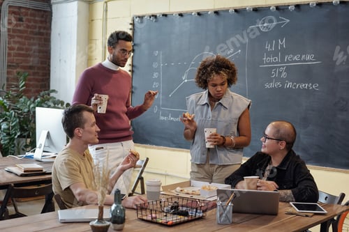 Preview: Group of young contemporary colleagues having pizza and drinks