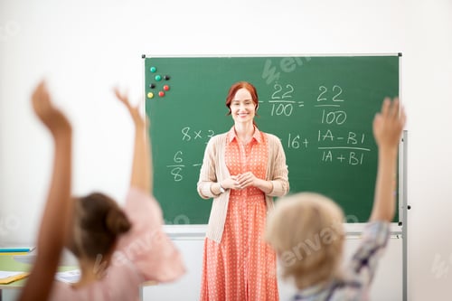 Preview: Math teacher standing near blackboard and looking at smart children