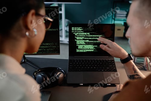 Preview: Male IT Programmer Pointing at Laptop Screen Discussing with Colleague Code at Workplace