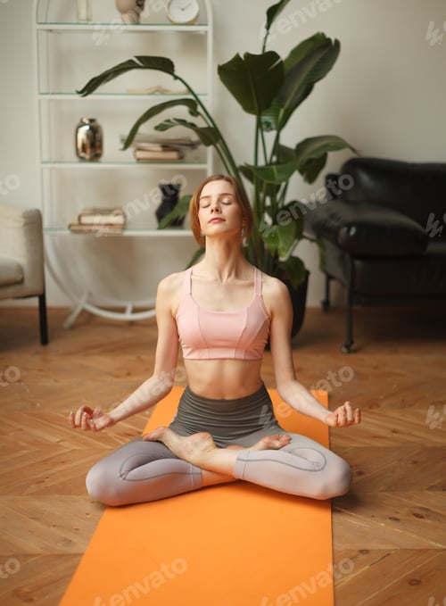 Preview: fitness female meditating in lotus pose at home