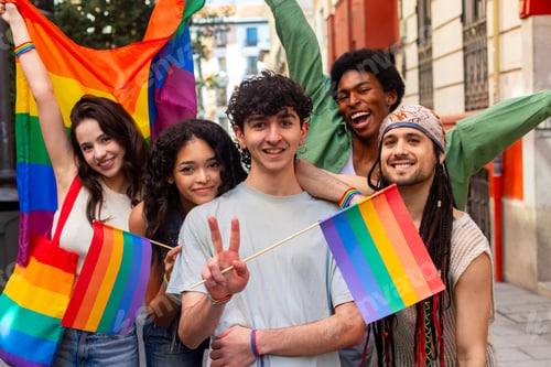 Preview: Young activists showing rainbow flags and peace sign at pride parade