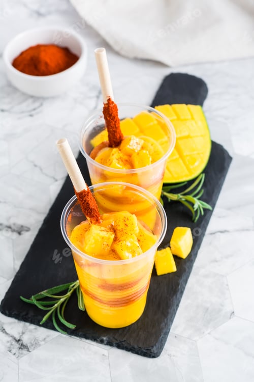 Preview: Mangonada mexican smoothie from mango with chamoy sauce and tamarind straw in plastic cups