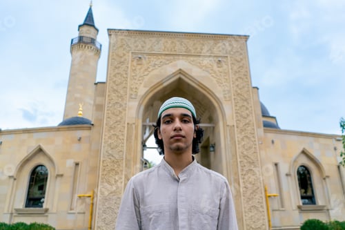 Preview: man of Muslim appearance leaving the mosque after prayer on a terrace with Islamic ornaments