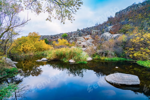Preview: A fast clean stream runs among smooth wet stones surrounded by tall dry lumps
