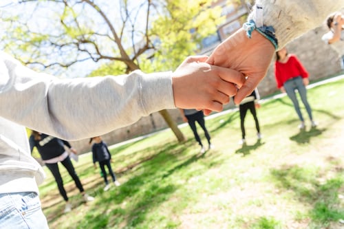 Preview: Group of adults and children holding hands in a circle of fellowship and friendship.