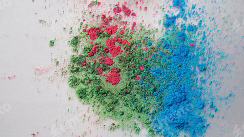 Preview: Top view of dry colorful inks falling in white liquid substance. Beautiful iridescent background of