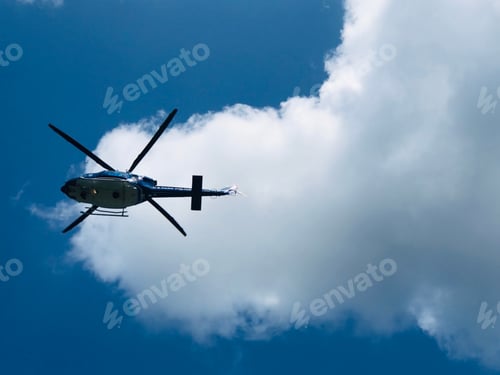 Preview: Helicopter flying overhead against blue sky and white cloud