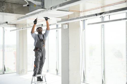 Preview: African American electrician repairing air conditioner indoors