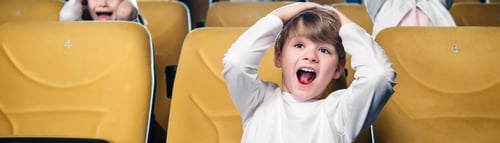 Preview: panoramic shot of excited boy screaming while watching movie in cinema