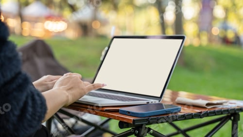 Preview: female using laptop computer on desk in park outdoor.