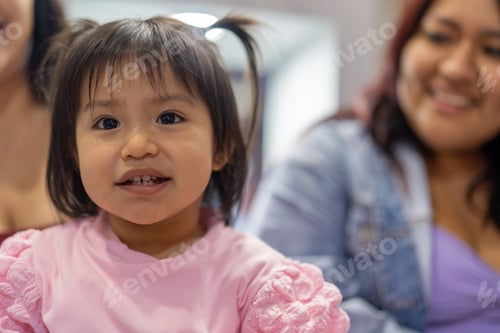 Preview: Little girl with pigtails waiting for dessert with family