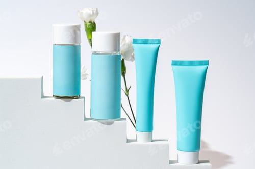 Preview: Cosmetics packaging. Set of different cosmetic bottles and tubes of cream on white podium