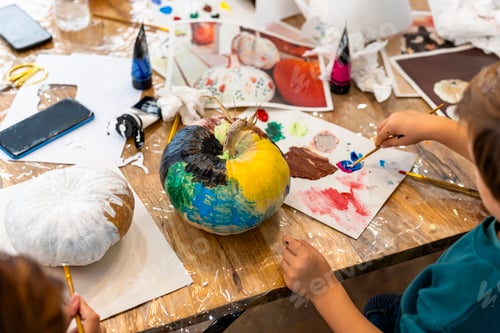 Preview: Children's painting class. Painting day with parents in class painting pumpkins.