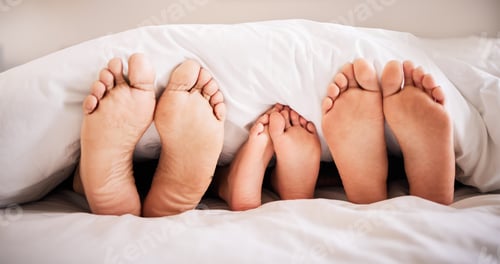 Preview: Sleeping, feet and family in bed together in the morning, lying in a row to relax in their home. Mo