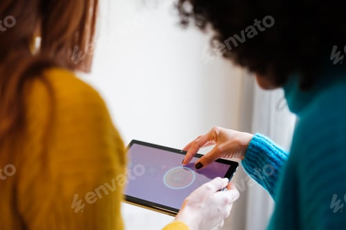 Preview: Two young friends using wireless technology for remote control of home applications.