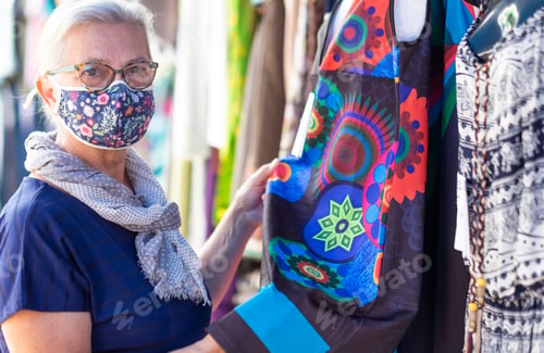Preview: Portrait of an elderly woman wearing a medical mask due to coronavirus while shopping