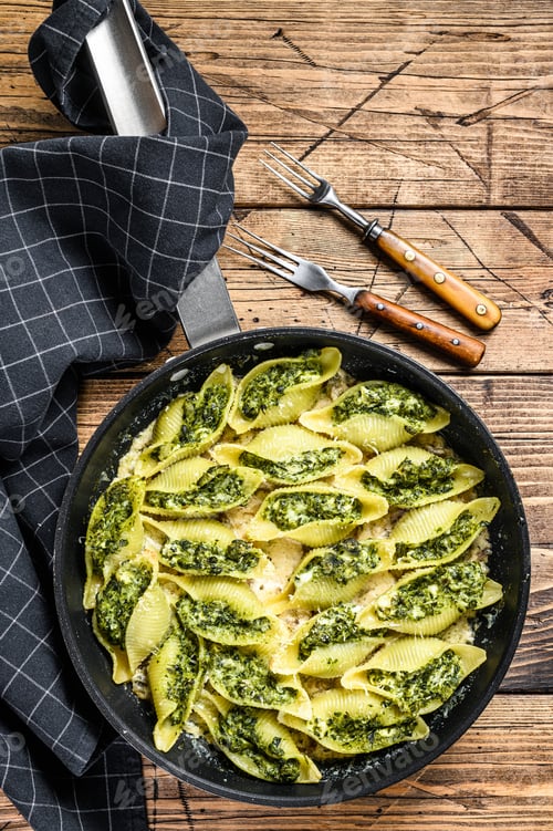 Preview: Jumbo shells pasta Conchiglioni stuffed with spinach and cheese baked with sauce in a pan.
