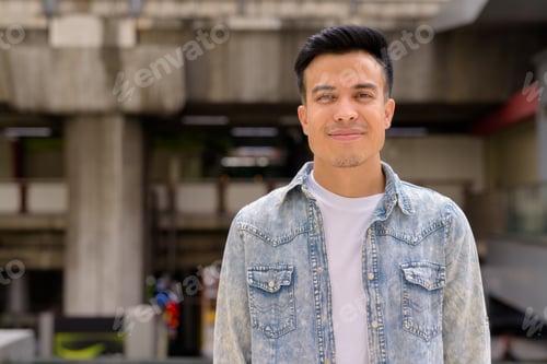 Preview: Portrait of handsome young man outdoors in city during summer