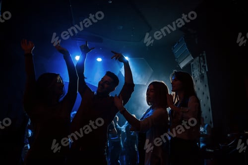 Preview: Happy youth. Group of people that enjoying dancing in the nightclub with beautiful lightings