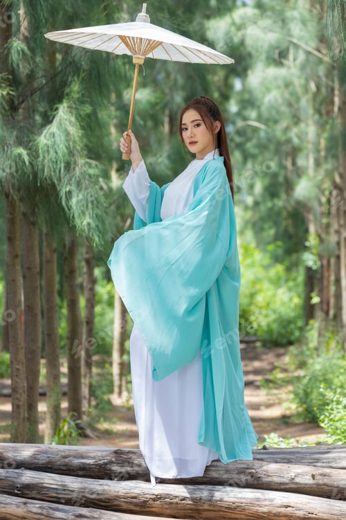 Preview: Young beautiful Asian woman dressed in ancient Chinese warrior style with ancient fan