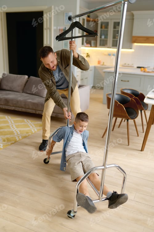 Preview: Father and son having fun with clothes hanger