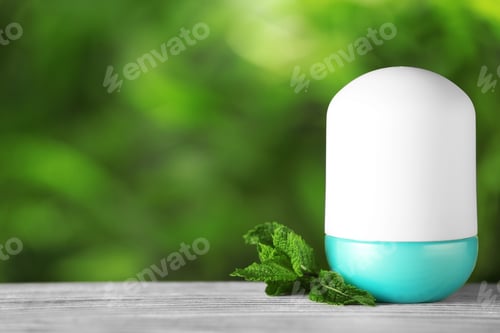 Preview: Natural roll-on deodorant with mint on wooden table against blurred green background. Space for text