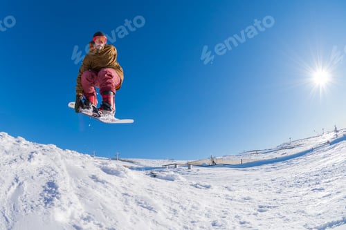 Preview: Snowboarder jumping against blue sky