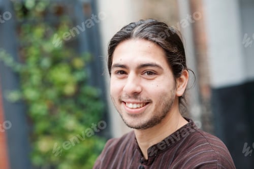 Preview: Young man smiling in a casual outdoor setting