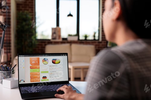 Preview: Office worker analyzing business charts on laptop