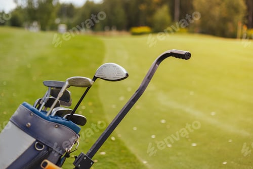 Preview: Golf bag trolley with clubs on green, copy space.