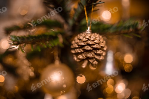 Preview: Golden Christmas Pinecone Ornament Hanging on Tree Branch