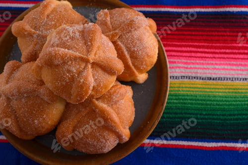 Preview: Pan de muerto on colorful serape. Day of the Dead celebration.