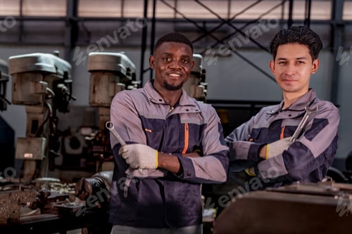 Preview: Two confident industrial technicians standing in a machine workshop