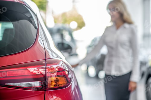 Preview: Rear headlight of car and woman
