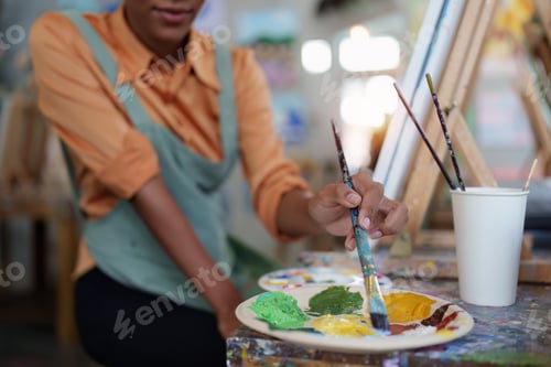 Preview: Beautiful american african artist woman painting in art studio at the university classroom